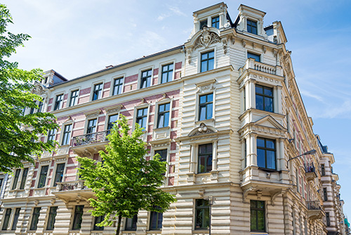 Agent de nettoyage parties communes copropriété Paris Agent Nova Hélios en train de nettoyer le couloir des parties communes d'un immeuble à Paris